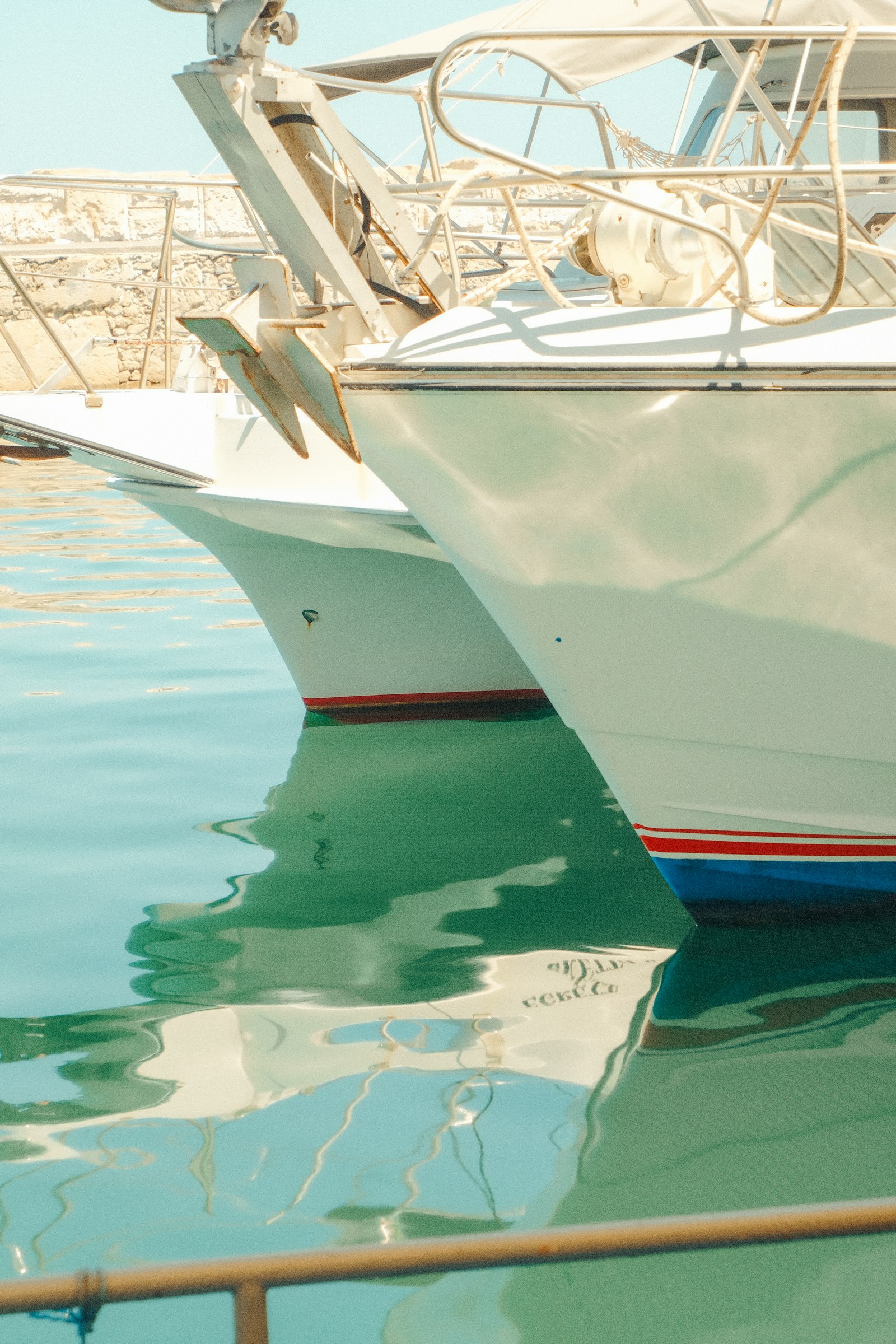 Two yachts moored in clear turquoise Mediterranean water
